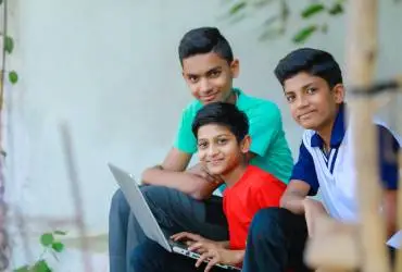 three boy students with a laptop